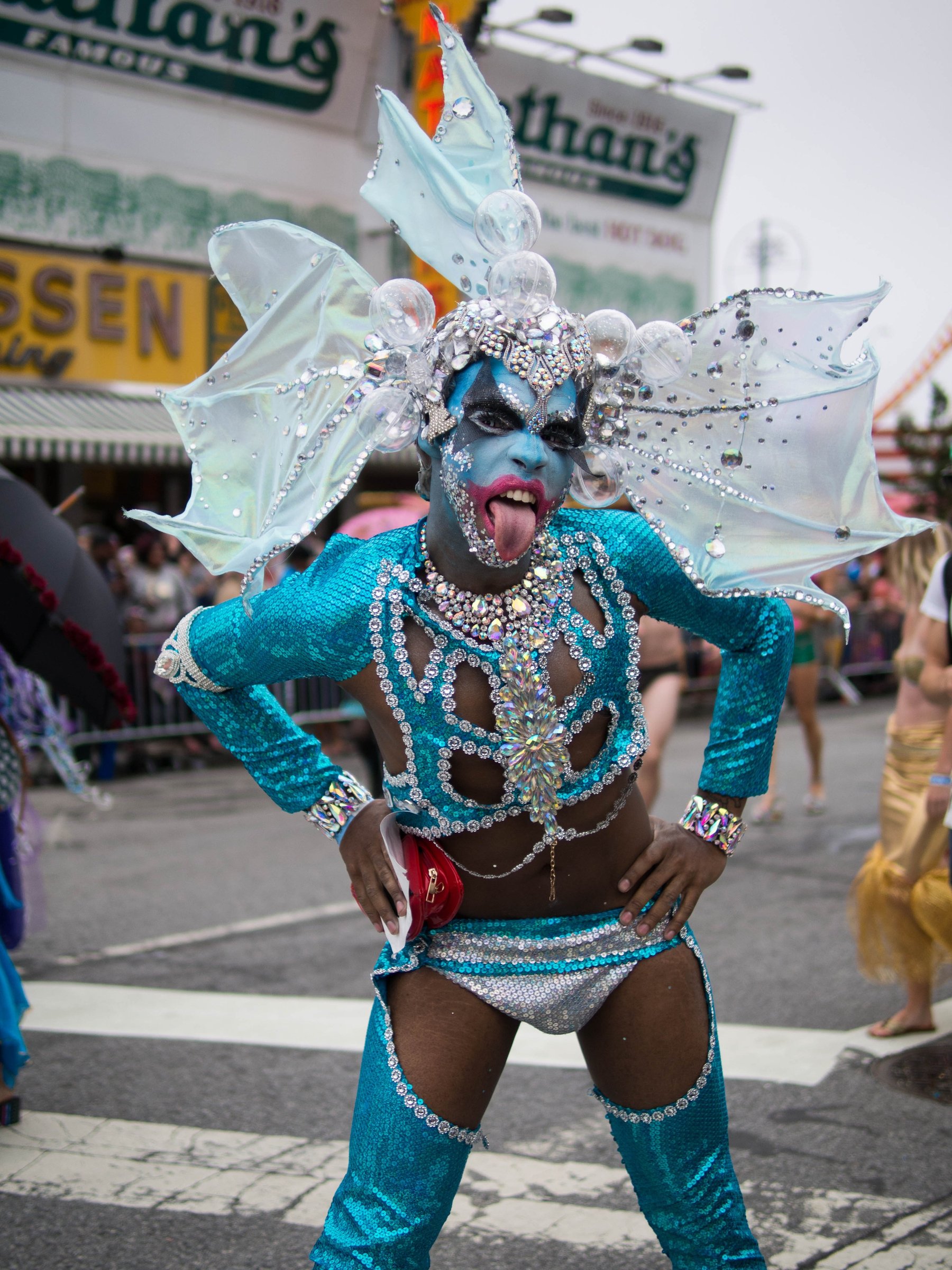 A parade dancer in turquoise with an elaborate white feathered headdress.